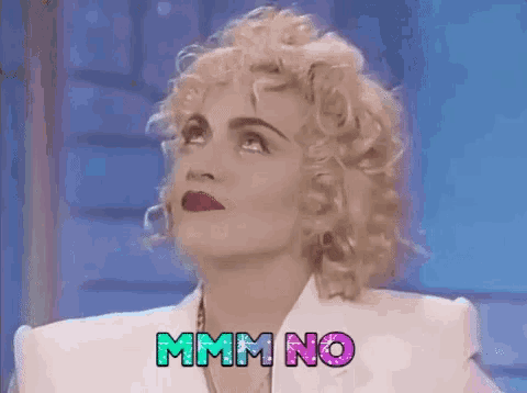 a woman with curly blonde hair is wearing a white jacket and says mmm no .