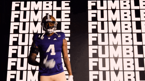 a football player stands in front of a wall that says fumble