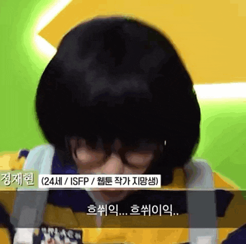 a man wearing glasses and a yellow jacket is talking in a foreign language .