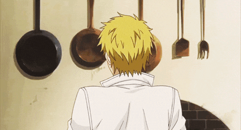 a man with yellow hair is standing in front of pots and pans hanging on a wall