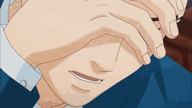 a close up of a man 's face with his hands covering his eyes