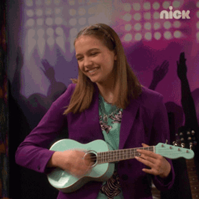 a girl in a purple jacket is playing a guitar with a nick logo in the background