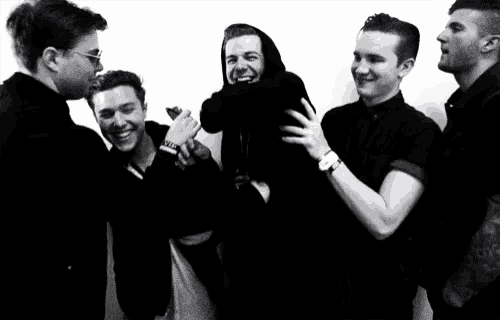 a group of young men are posing for a picture and one of them is wearing a hoodie