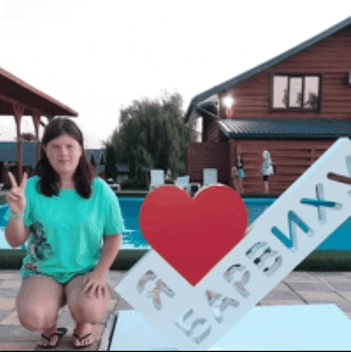 a girl is kneeling in front of a sign that says i love russia