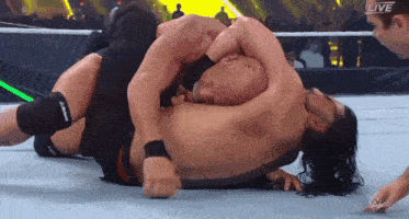 two men are wrestling in a wrestling ring with the words live on the bottom of the screen