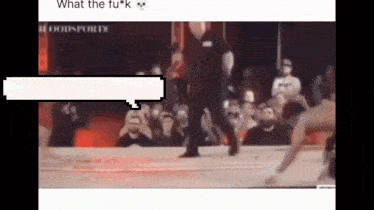 a blurry picture of a wrestling match with a speech bubble that says what the fuck .