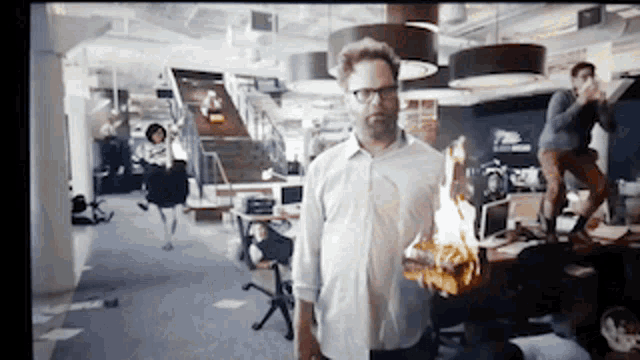a man in a white shirt is holding a burning object