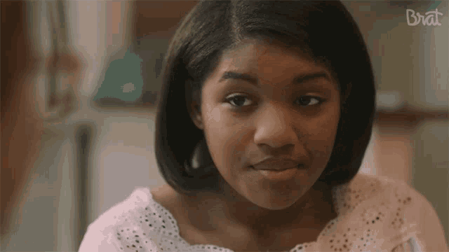 a close up of a girl 's face with the word brat in the upper right corner