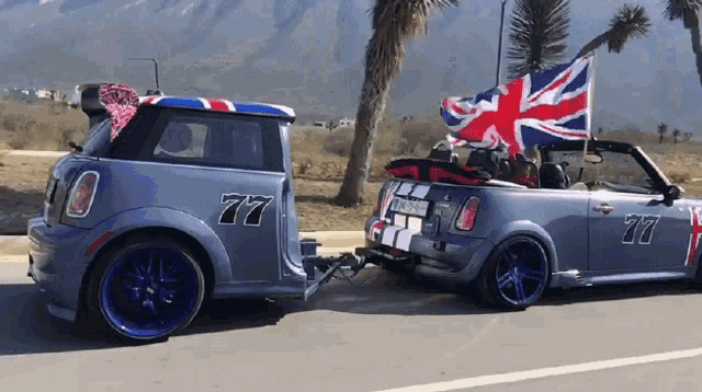 a car with the number 77 on the side is pulling another car