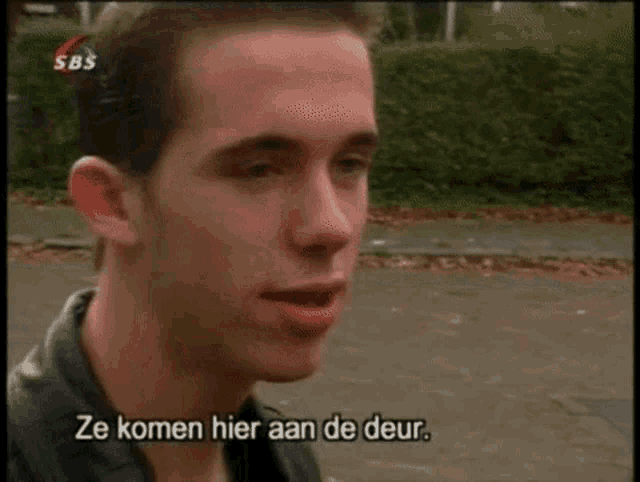 a man in a black jacket is talking to someone in a foreign language with subtitles that say ze komen hier aan de deur
