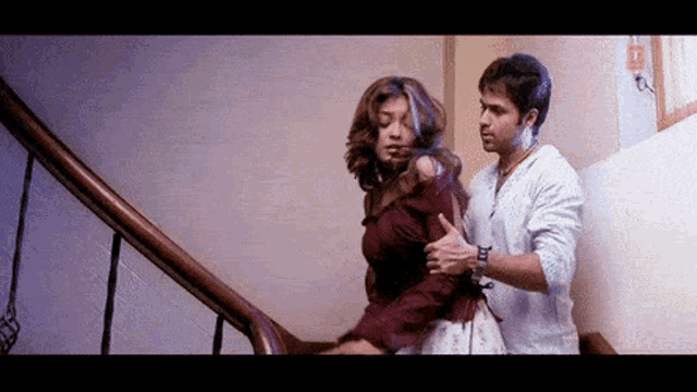 a man and a woman are walking down a set of stairs together .