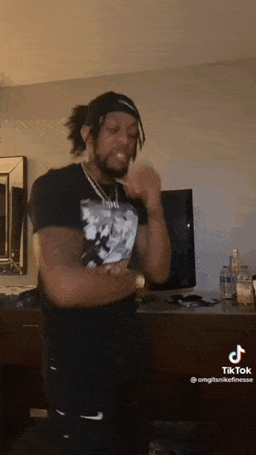 a man in a black shirt is standing in a living room .