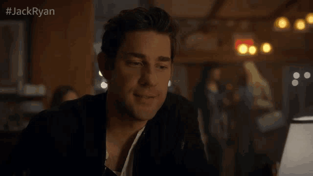 a man is sitting at a table in a restaurant with #jackryan on the bottom