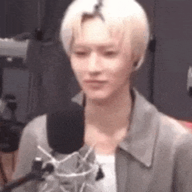 a young man is standing in front of a microphone and talking into it .