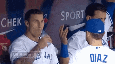 a baseball player named diaz is talking to another player in a dugout