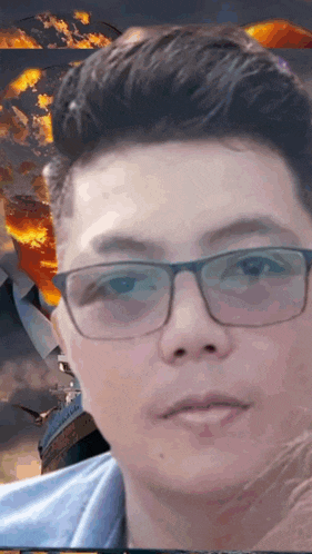 a man wearing glasses looks at the camera in front of a fire background