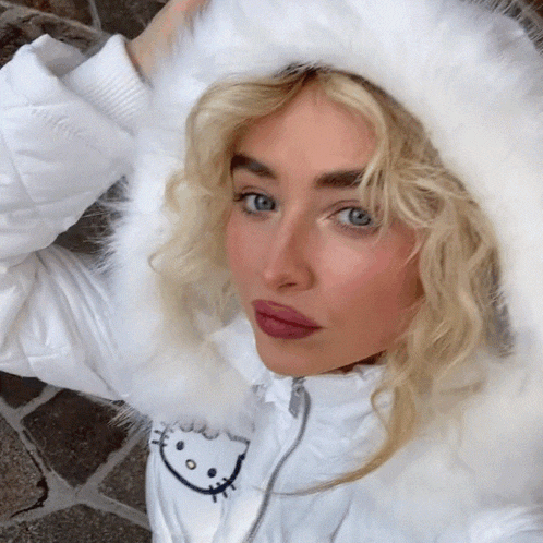 a woman wearing a white hello kitty jacket