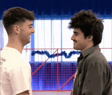 two men looking at each other with one wearing a white shirt that says learn dance
