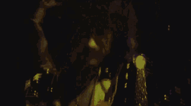 a man in a suit is playing a guitar in a dark room