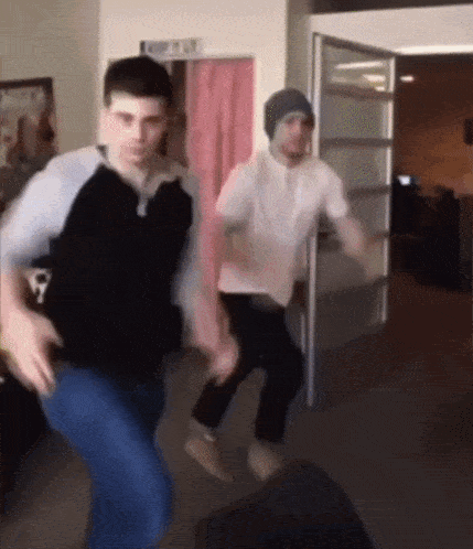 two men are dancing in a room with a sign on the wall that says ' no entry '