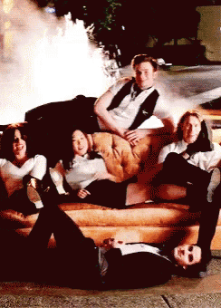 a group of people laying on a couch with a man laying on the ground