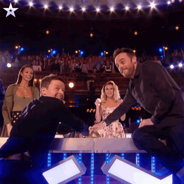 two men on a stage with a star in the upper right corner