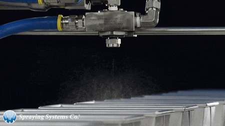 a spraying system is being used to spray a row of white containers