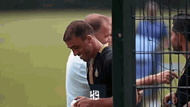 a man behind a fence with a shirt that says hb on it
