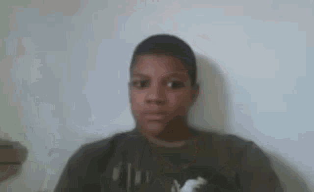 a young boy is making a funny face in front of a camera .