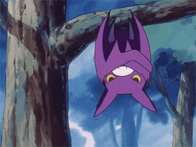 a purple bat hangs upside down from a tree branch