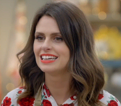 a woman wearing a floral shirt is smiling and looking at the camera .