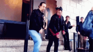 a group of men are dancing on steps outside of a building .