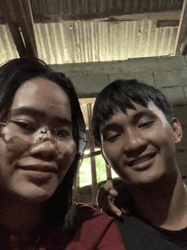 a man and a woman are posing for a picture and smiling for the camera