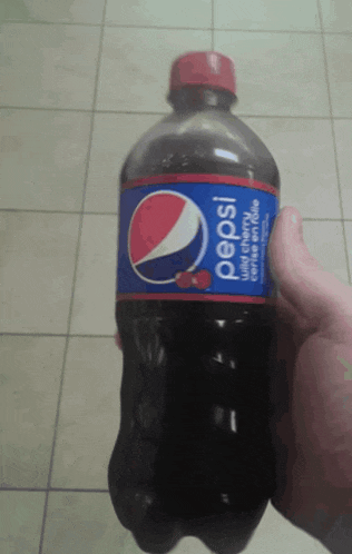 a person is holding a bottle of pepsi with cherry flavor