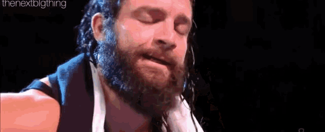 a man with a beard and a towel around his neck .