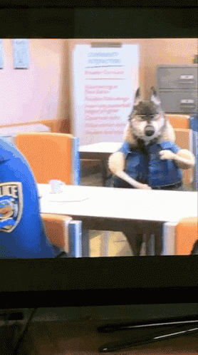 a tv screen shows a police officer and a wolf