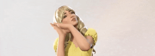 a woman in a yellow dress is flexing her arm