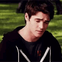 a young man wearing a black hoodie and a black t-shirt with the word gf on it