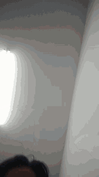 a person is looking up at the ceiling with a light on it .