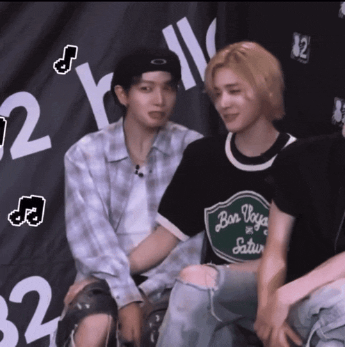 a person wearing a shirt that says bon voyage saturday sits next to another person