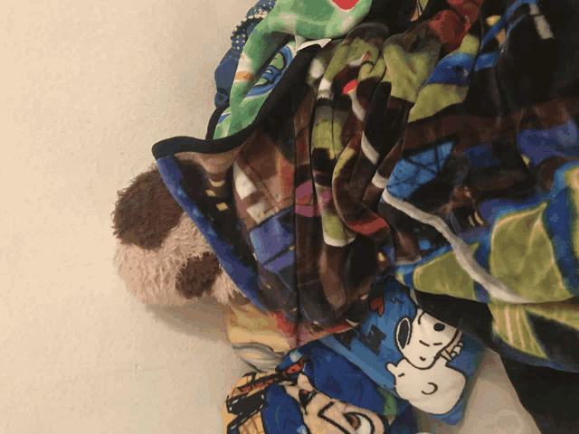 a pile of blankets with snoopy on one of them