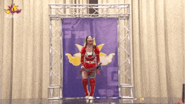 a woman in a superhero costume is standing in front of a banner that says gtmv