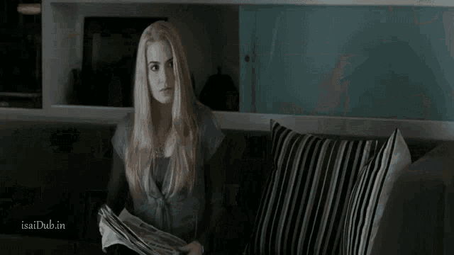 a woman is standing in front of a bookshelf with isaidub.in written on the bottom