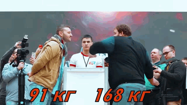 two men standing in front of a sign that says " 91 kg 168 kg "