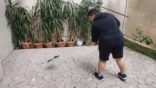 a man is sweeping the ground with a broom in a yard .