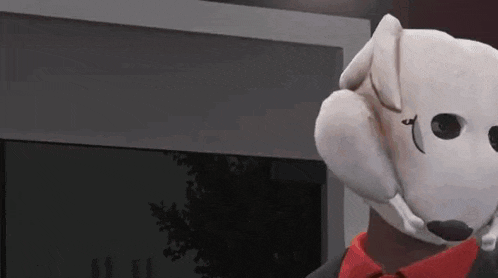 a stuffed animal wearing a dog mask and a red tie is standing in a room .