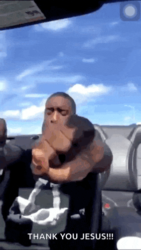 a man in a car is pointing at the camera with the words thank you jesus written below him