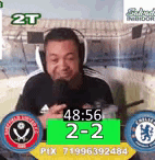 a man wearing headphones is sitting in front of a microphone and a scoreboard .
