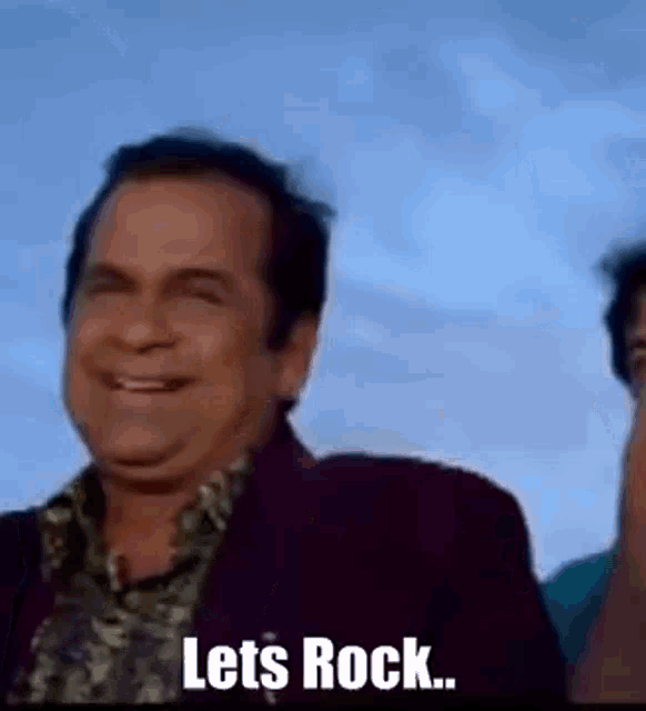 a man in a suit is smiling and saying `` let 's rock ... '' .