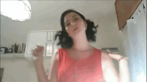a woman in a red dress is standing in a kitchen .
